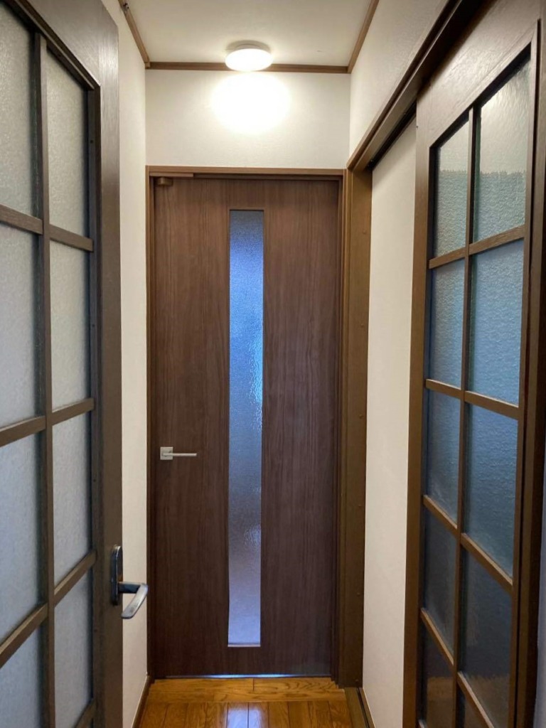 施工後の廊下。木目の開き戸と既存の建具